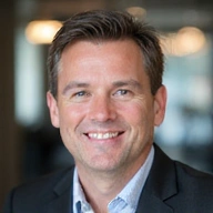 A professional headshot of John Doe, a man with a friendly smile and intelligent eyes.